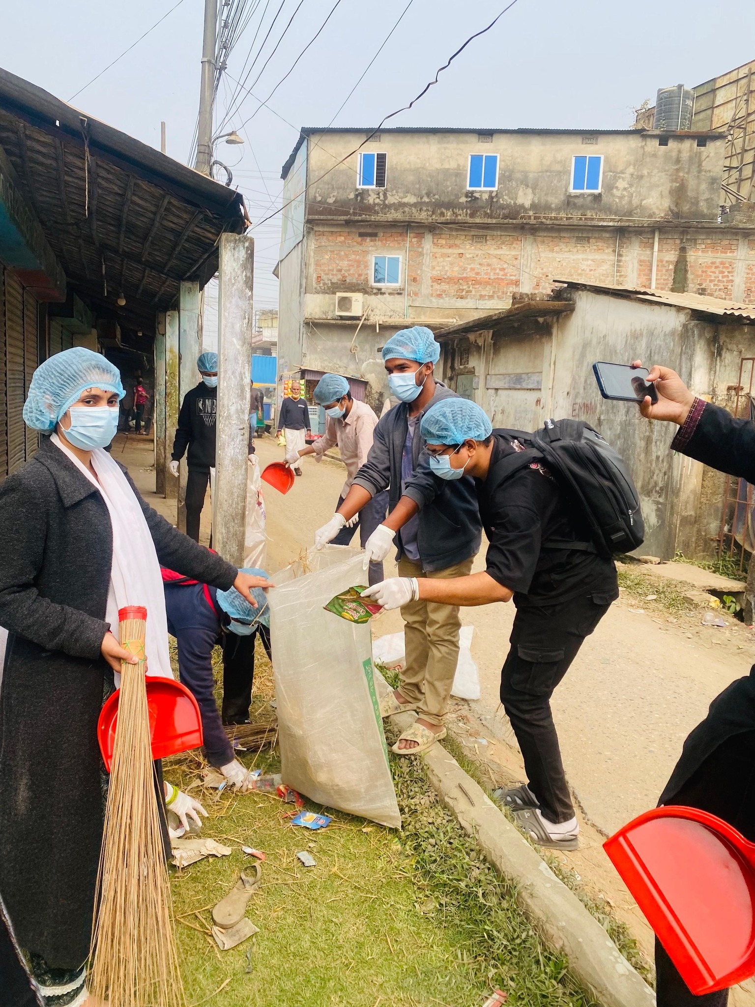 Community Volunteers Participate in a Neighborhood Cleaning Drive, Collecting Trash and Sweeping Streets for Hygiene.